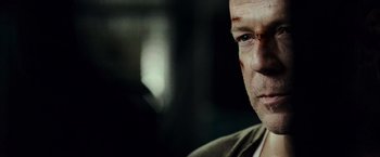 Movie still from “Live Free or Die Hard” (2007), directed by Len Wiseman – A man's face in a dark room; Close Up shot, Over the shoulder angle