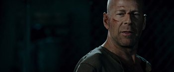 Movie still from “Live Free or Die Hard” (2007), directed by Len Wiseman – A man with a shaved head and a scar on his face; Close Up shot, Low angle