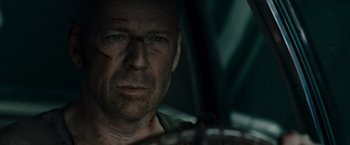Movie still from “Live Free or Die Hard” (2007), directed by Len Wiseman – A person wearing a hat; Close Up shot, Over the shoulder angle