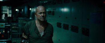 Movie still from “Live Free or Die Hard” (2007), directed by Len Wiseman – A man standing in front of a wall with lights on it; Medium shot, Low angle