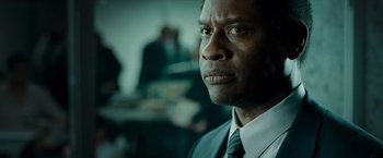 Movie still from “Live Free or Die Hard” (2007), directed by Len Wiseman – A man wearing a suit and tie in a room; Close Up shot, Low angle