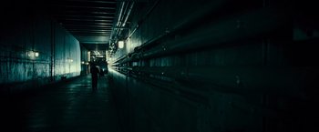Movie still from “Live Free or Die Hard” (2007), directed by Len Wiseman – People walking down a dark hallway in a building; Extreme Wide shot, High angle