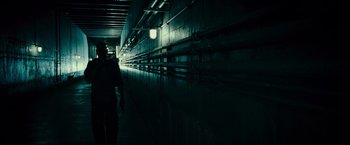 Movie still from “Live Free or Die Hard” (2007), directed by Len Wiseman – A person walking down a dark hallway in a building; Wide shot, Low angle
