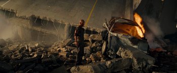 Movie still from “Live Free or Die Hard” (2007), directed by Len Wiseman – A man standing next to a pile of rubble next to a car; Wide shot, High angle