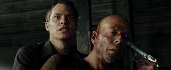 Movie still from “Live Free or Die Hard” (2007), directed by Len Wiseman – A man and a man with bruises on their face; Close Up shot, Low angle