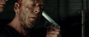 Movie still from “Live Free or Die Hard” (2007), directed by Len Wiseman – A person holding a gun in a room; Close Up shot, Overhead angle