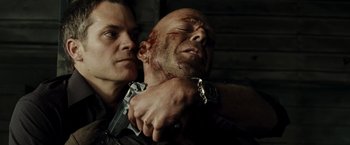 Movie still from “Live Free or Die Hard” (2007), directed by Len Wiseman – A man holding a gun over another man's face; Close Up shot, Low angle