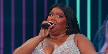 Movie still from “Lizzo: Live in Concert” (2022), directed by Brad Duns – A person singing on a microphone; Close Up shot, Low angle