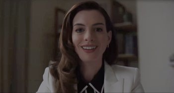 Movie still from “Locked Down” (2021), directed by Doug Liman – A person wearing a suit and smiling; Close Up shot, Low angle