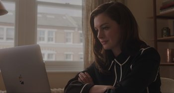 Movie still from “Locked Down” (2021), directed by Doug Liman – A beautiful young woman sitting in front of a laptop computer; Close Up shot, Over the shoulder angle