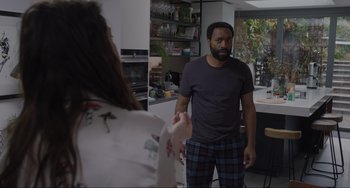 Movie still from “Locked Down” (2021), directed by Doug Liman – A man and a woman are standing in a kitchen; Medium shot, Over the shoulder angle