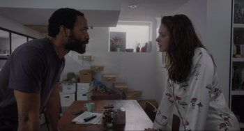 Movie still from “Locked Down” (2021), directed by Doug Liman – A man and a woman talking to each other in front of a wooden table; Medium shot, Over the shoulder angle