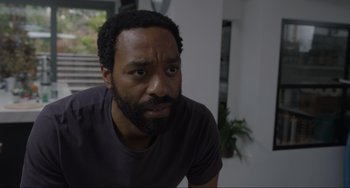 Movie still from “Locked Down” (2021), directed by Doug Liman – A person with a beard looking at the camera; Close Up shot, Low angle