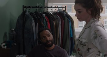 Movie still from “Locked Down” (2021), directed by Doug Liman – A man and a woman standing in front of clothes; Medium shot, Over the shoulder angle