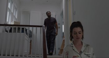 Movie still from “Locked Down” (2021), directed by Doug Liman – A man and a woman walking down the stairs of a house; Medium shot, Low angle