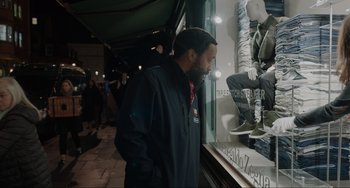 Movie still from “Locked Down” (2021), directed by Doug Liman – A man standing in front of a store window; Medium shot, Over the shoulder angle