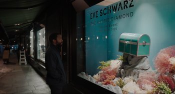 Movie still from “Locked Down” (2021), directed by Doug Liman – A man standing in front of a store window; Medium shot, Over the shoulder angle