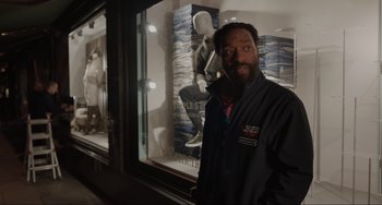 Movie still from “Locked Down” (2021), directed by Doug Liman – A man standing in front of a store window; Medium shot, Over the shoulder angle