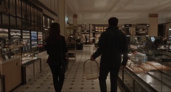 Movie still from “Locked Down” (2021), directed by Doug Liman – A man and a woman walking down a hall way; Wide shot, Over the shoulder angle
