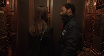 Movie still from “Locked Down” (2021), directed by Doug Liman – A man and a woman standing next to each other in an elevator; Close Up shot, Over the shoulder angle