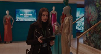 Movie still from “Locked Down” (2021), directed by Doug Liman – A woman in a black jacket is looking at a tablet; Medium shot, Over the shoulder angle