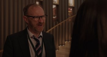 Movie still from “Locked Down” (2021), directed by Doug Liman – A man wearing a suit and tie talking to a woman; Close Up shot, Over the shoulder angle