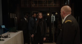 Movie still from “Locked Down” (2021), directed by Doug Liman – A group of people standing in front of a building; Medium shot, Over the shoulder angle