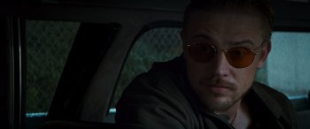 Movie still from “Logan” (2017), directed by James Mangold – A person in a car wearing sunglasses; Close Up shot, Over the shoulder angle