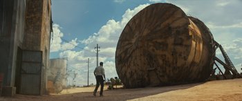 Movie still from “Logan” (2017), directed by James Mangold – A man standing in front of a large object in the desert; Extreme Wide shot, Low angle