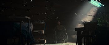 Movie still from “Logan” (2017), directed by James Mangold – An old man sitting in a wheel chair in a dark room; Wide shot, Low angle