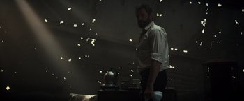 Movie still from “Logan” (2017), directed by James Mangold – A man standing in front of a stove in a dark room; Medium shot, Low angle