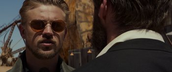 Movie still from “Logan” (2017), directed by James Mangold – A man in a suit and sunglasses talking to another man in a suit; Close Up shot, Over the shoulder angle