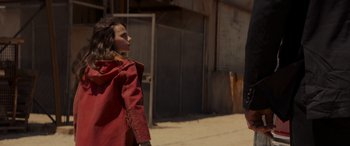 Movie still from “Logan” (2017), directed by James Mangold – A woman in a red jacket standing next to a man; Medium shot, Over the shoulder angle