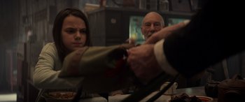 Movie still from “Logan” (2017), directed by James Mangold – A man holding a knife in front of a woman; Close Up shot, Over the shoulder angle