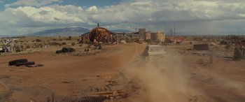 Movie still from “Logan” (2017), directed by James Mangold – A car driving down a dirt road near a building; Extreme Wide shot, Low angle