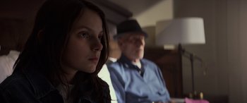Movie still from “Logan” (2017), directed by James Mangold – A young girl and an older man sitting in a room; Close Up shot, Over the shoulder angle