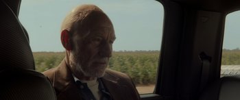 Movie still from “Logan” (2017), directed by James Mangold – An older man sitting in the back of a car; Close Up shot, Over the shoulder angle