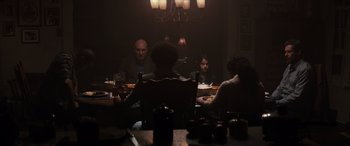 Movie still from “Logan” (2017), directed by James Mangold – A group of people sitting at a dinner table; Medium shot, Over the shoulder angle