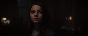 Movie still from “Logan” (2017), directed by James Mangold – A young girl with long dark hair stares into the camera; Close Up shot, Low angle