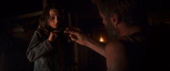 Movie still from “Logan” (2017), directed by James Mangold – A man looking in the mirror while a woman looks on; Close Up shot, Over the shoulder angle