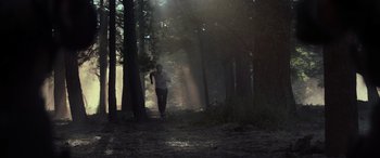 Movie still from “Logan” (2017), directed by James Mangold – A man running through the woods on a trail; Extreme Wide shot, Low angle