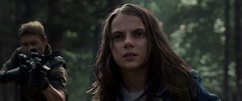 Movie still from “Logan” (2017), directed by James Mangold – A girl with long hair is standing in the woods; Close Up shot, Low angle