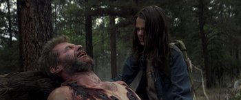 Movie still from “Logan” (2017), directed by James Mangold – A woman standing next to a man laying on the ground; Close Up shot, Low angle