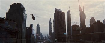 Movie still from “Looper” (2012), directed by Rian Johnson – A helicopter flying over a city with skyscrapers in the background; Extreme Wide shot, High angle