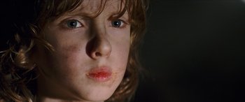 Movie still from “Looper” (2012), directed by Rian Johnson – A young child's face with red lips; Close Up shot, Low angle