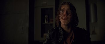 Movie still from “Looper” (2012), directed by Rian Johnson – A person with long hair and a leather jacket; Close Up shot, Low angle