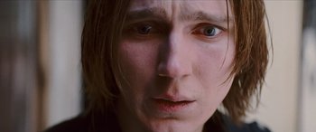 Movie still from “Looper” (2012), directed by Rian Johnson – A person with long hair; Extreme Close Up shot, Low angle