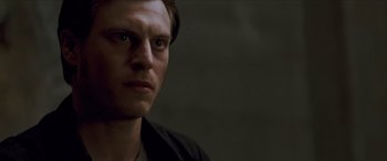 Movie still from “Looper” (2012), directed by Rian Johnson – A person wearing a black shirt; Close Up shot, Low angle