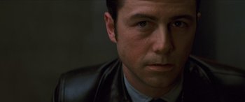 Movie still from “Looper” (2012), directed by Rian Johnson – A person wearing a suit and tie; Close Up shot, Low angle