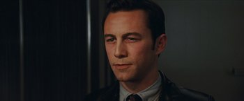 Movie still from “Looper” (2012), directed by Rian Johnson – A person wearing a suit and tie; Close Up shot, High angle